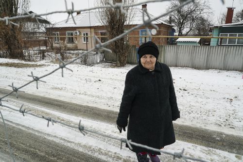 Raisa Yakovleva, in Russia, approaches the barbed wire fence to talk to her sister Valentina, in the Ukraine - the pair are separated by a barbed wire fence.
