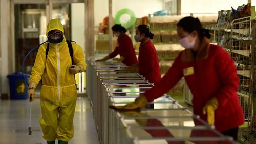 Employees spray disinfectant and wipe surfaces as part of preventative measures against the COVID-19 coronavirus at the Pyongyang Children's Department Store in Pyongyang.