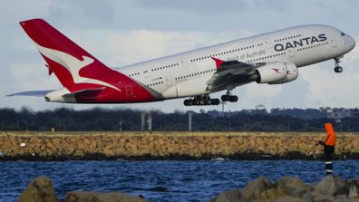 A Qantas A380 takes off from Sydney Airport over Botany Bay.