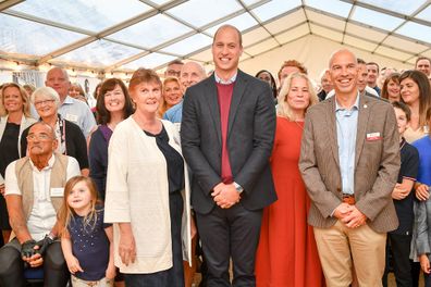 Prince William poses for a group photograph during a visit to the Fire Fighters Charity's Harcombe House.