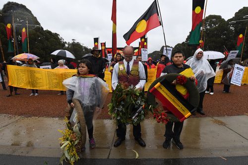 Members of the Frontier war contingent prepare to lay a wreath at the stone of remembrance at the end of the ANZAC Day march at the Australian War Memorial in Canberra.