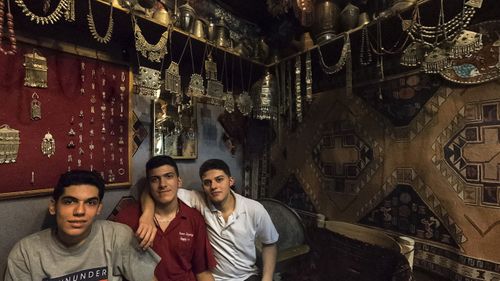 Some proud storeowners pose for a photo in the souq. 