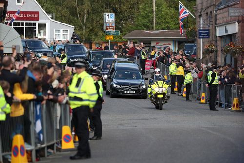 Members of the public line the streets in Ballater, Scotland