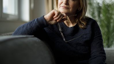 Portrait of worried senior woman sitting on sofa at home