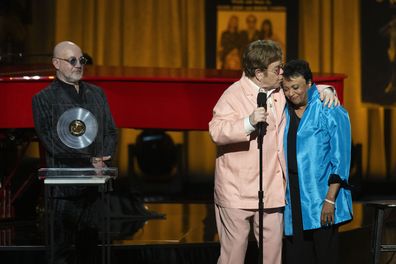 Elton John gives a kiss to Librarian of Congress Carla Hayden, right, after being awarded the Gershwin Prize with fellow honoree Bernie Taupin, left, during the 2024 Library of Congress Gershwin Prize for Popular Song tribute concert honoring John and Taupin at DAR Constitution Hall on Wednesday, March 20, 2024, in Washington. (AP Photo/Kevin Wolf)