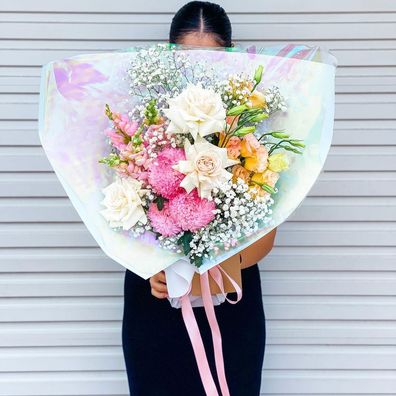 Florist Natasha Tarabey holding colourful bouquet.