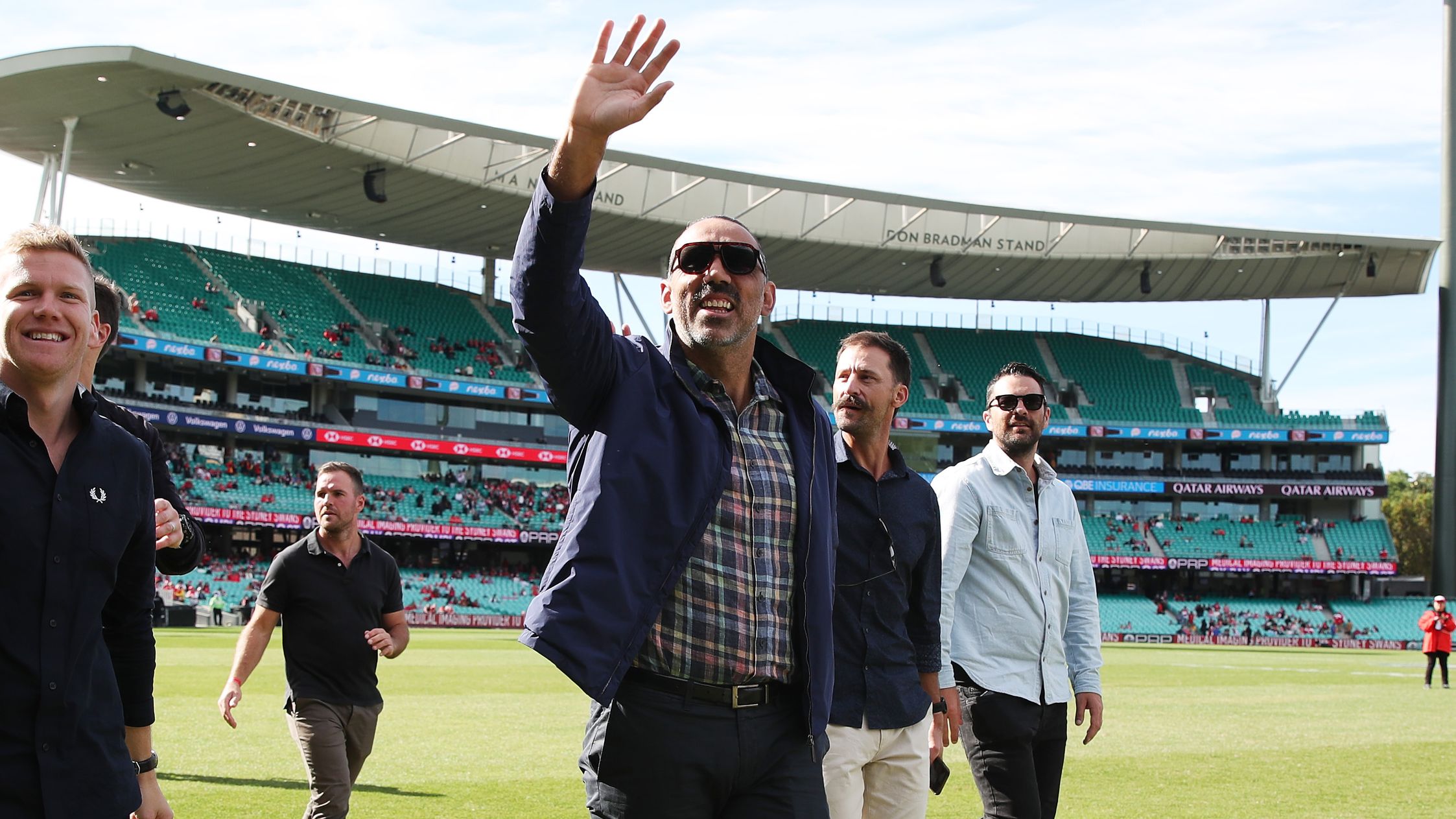 Adam Goodes waves to fans while completing a lap of honour.