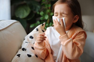 Little girl blowing her nose sick