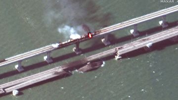 This satellite image provided by Maxar Technologies shows damage to the Kerch Bridge, which connects the Crimean Peninsula with Russia crossing a strait between the Black Sea and the Sea of Azov, and rail cars on fire on Saturday, Oct. 8, 2022. (Maxar Technologies via AP)