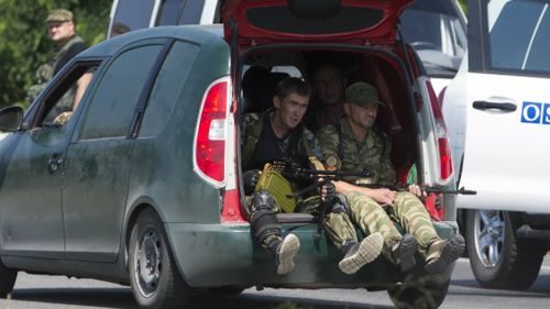 Pro-Russian rebels pass the OSCE convoy. (AAP)