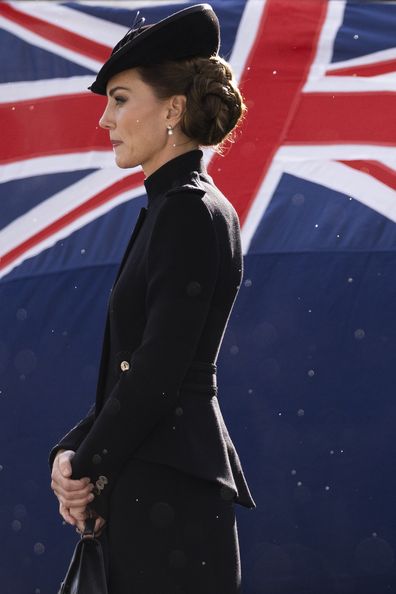 Catherine, Princess of Wales walks past a Union flag as rain falls while meeting with military personnel during a visit to Army Training Centre Pirbright on September 16, 2022 in Guildford, England. 