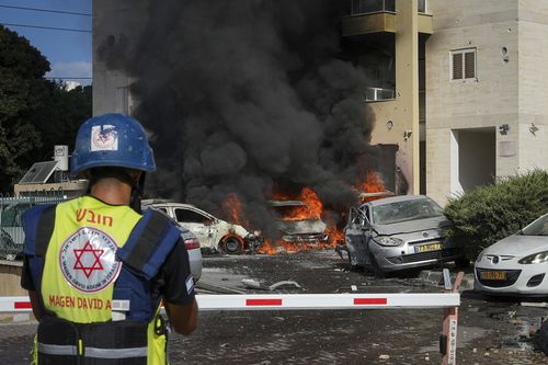 Cars are burning after a rocket fired from the Gaza Strip hit a parking lot and a residential building in Ashkelon, southern Israel, Saturday, Oct. 7, 2023.