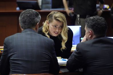 Actress Amber Heard talks to her attorneys in the courtroom at the Fairfax County Circuit Court in Fairfax, Va., Monday April 18, 2022. Actor Johnny Depp sued his ex-wife Amber Heard for libel in Fairfax County Circuit Court after she wrote an op-ed piece in The Washington Post in 2018 referring to herself as a "public figure representing domestic abuse." (AP Photo/Steve Helber, Pool)
