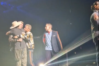Nick Carter is comforted by fellow Backstreet Boy band members during performance in London.