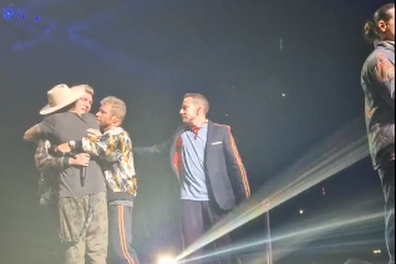 Nick Carter is comforted by fellow Backstreet Boy band members during a performance in London.