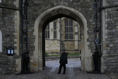 Police guard the Henry VIII gate at Windsor Castle at Windsor, England on Christmas Day, Saturday, Dec. 25, 2021. Britain's Queen Elizabeth II has stayed at Windsor Castle instead of spending Christmas at her Sandringham estate due to the ongoing COVID-19 pandemic. (AP Photo/Alastair Grant)