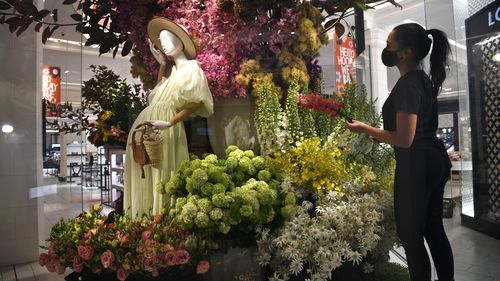 David Jones Visual merchandise manager Tiffany Vicho applies the finishing touches to David Jones floral arrangements at the store which has been closed for months.