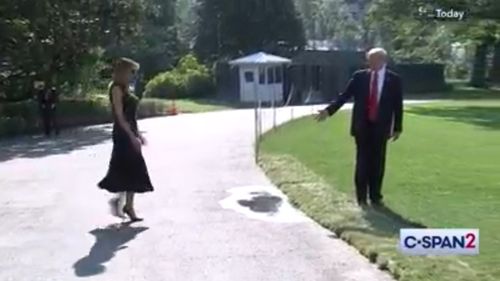 As the original footage plays on, Melania Trump enters the camera shot where Mr Trump is warning her not to step in the puddle.