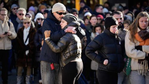 People cry as they attend a memorial procession in Crans-Montana, Swiss Alps, Switzerland, Sunday, Jan. 4, 2026, after a devastating fire in Le Constellation bar left dead and injured during the New Year's celebrations. (AP Photo/Baz Ratner)