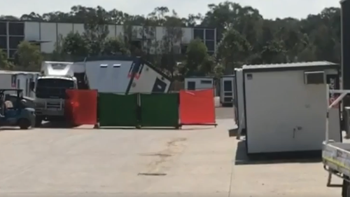 Police rescue crews were unable to save the worker who is believed to have been unloading a portable block from a vehicle when he was struck by the load. (9NEWS)