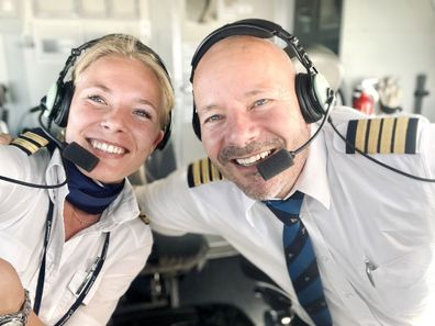 The father and daughter duo posing in the cockpit