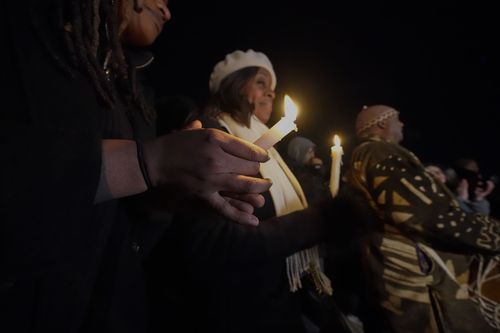People hold candles at a candlelight vigil for Tyre Nichols, who died after being beaten by Memphis police officers, in Memphis, Tenn., Thursday, Jan. 26, 2023. 