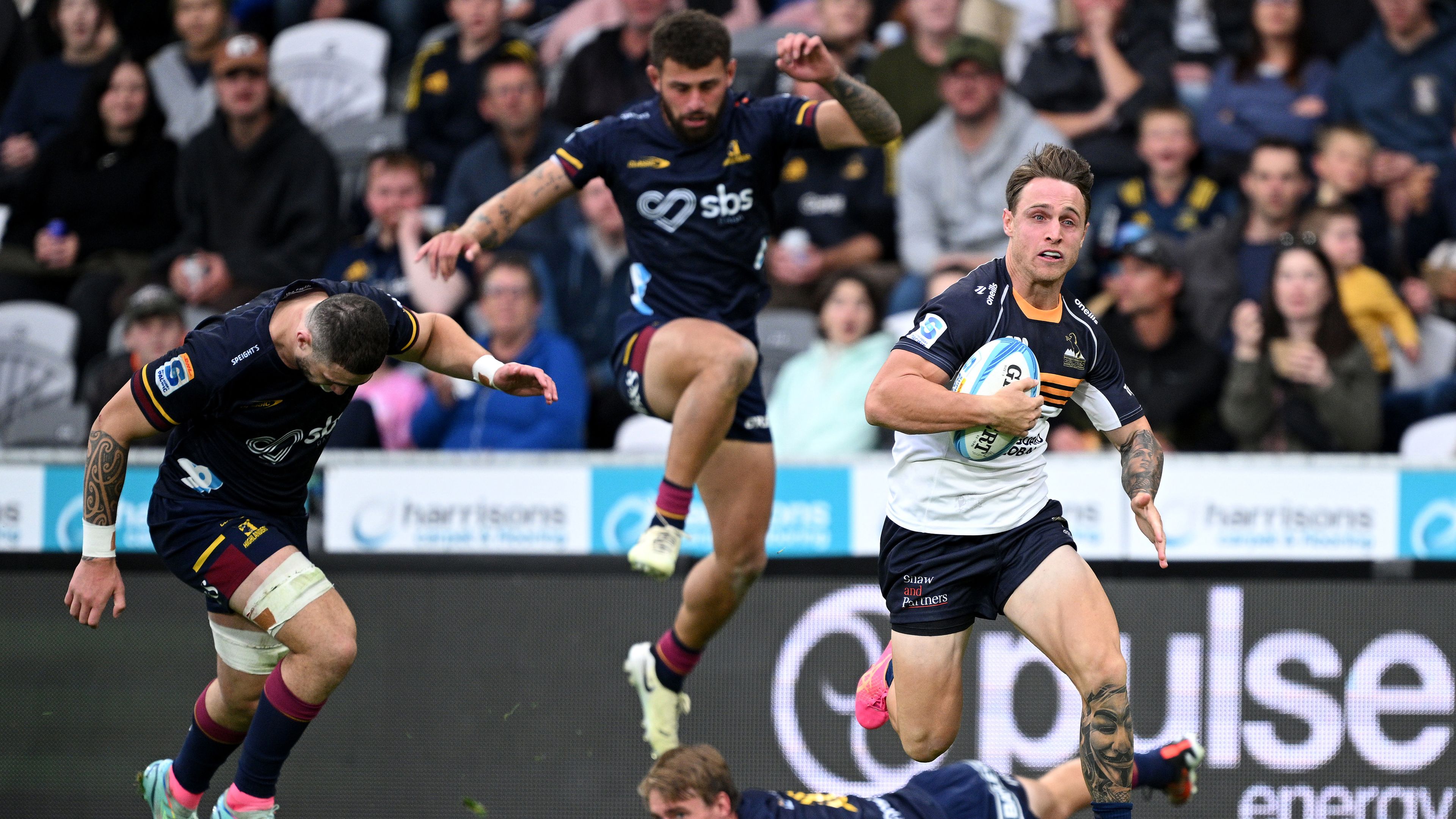 Corey Toole of the Brumbies charges towards the try line to score.