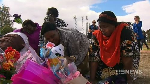 Members of the Sudanese community mourning at the scene of the tragic crash. (9NEWS)