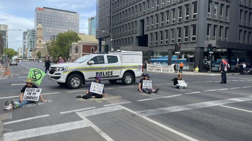 Extinction Rebellion protesters have glued themselves to Flinders Street in Adelaide.