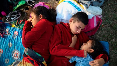 The Zelaya siblings from El Salvador huddle together on a soccer field. (AP)