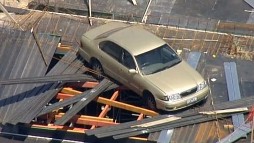 The car was left resting on scaffolding two stories high. (9NEWS)
