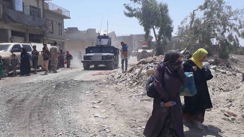 Mosul residents walking down the street. (Owen Holdaway)