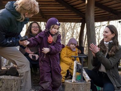 The Duchess of Cambridge encourages a little girl on a visit to Stenurten Forest Kindergarten  in Copenhagen on her solo visit. 