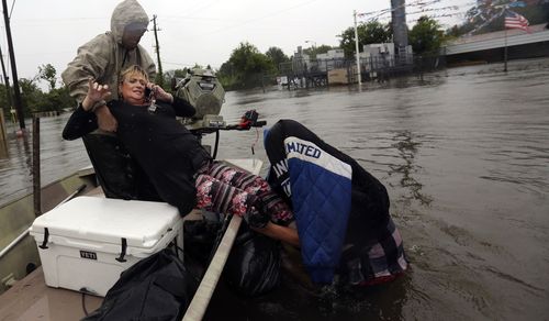 Rhonda Worthington is lifted into a boat while on her cell phone with a 911 dispatcher after her car become stuck in rising floodwaters. (AP)