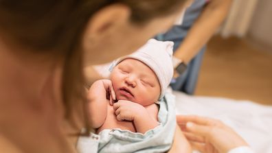 New mum holding her baby in hospital