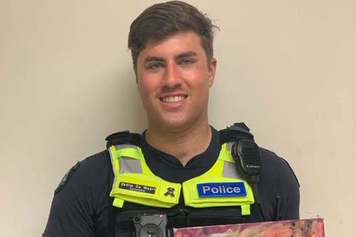 Senior Constable Vadim de Waart-Hottart, shown holding a portrait of himself, painted by an appreciative community member.