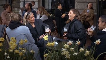 People chat and drink outside a bar in Stockholm, Sweden. Sweden is pursuing relatively liberal policies to fight the coronavirus pandemic.