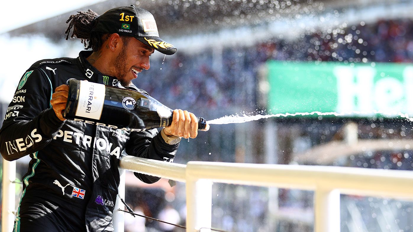 Race winner Lewis Hamilton of Great Britain and Mercedes GP celebrates on the podium 