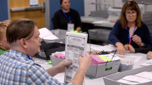 Officials in the crucial Washoe County, Nevada, sort through early votes.