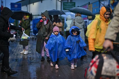 People, mainly women and children, make their way through Medyka border crossing during the evening after journeying from war-torn Ukraine on April 01, 2022 in Medyka, Poland. More than 4 million people have fled Ukraine since the Russian invasion of that country on Feb. 24. Millions more have been internally displaced. (Photo by Jeff J Mitchell/Getty Images)