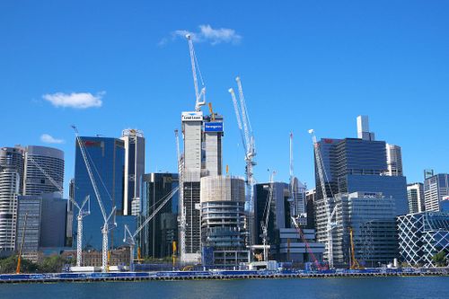 The 24-year-old who illegally climbed to the top of a Darling Harbour crane and jumped off has been charged.