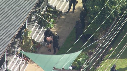 A man appears to have been taken into police custody at an ongoing police operation at Condell Park.