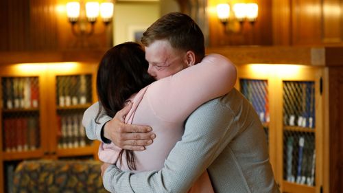 Lilly Ross, left, hugs face transplant recipient Andy Sandness as they first meet in a library at the Mayo Clinic. (AAP)