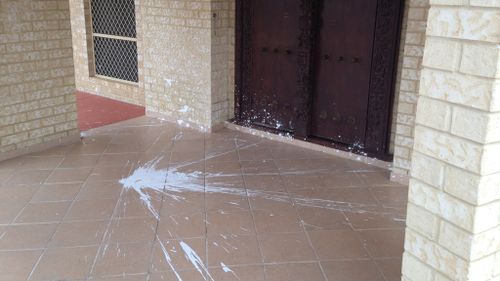 White paint was splashed over the main entrance, front porch and brick walls. (9NEWS)