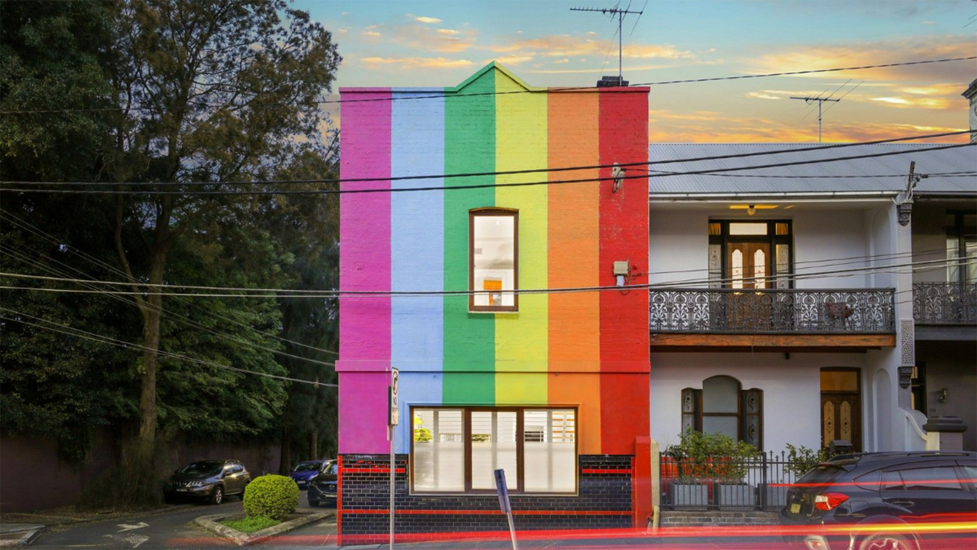 Exterior of home features the pride flag and a Freddie Mercury mural