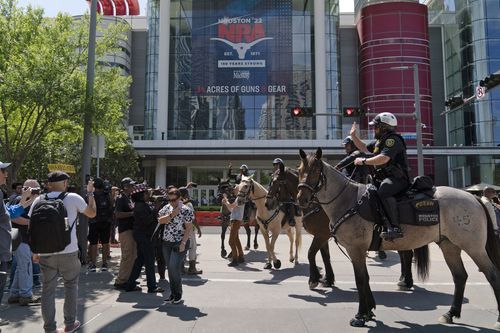 Mounted police officers tell protesters to move back across the street from the National Rifle Association annual meeting at the George R. Brown Convention Center in Houston, Friday, May 27, 2022. (AP Photo/Jae C. Hong)