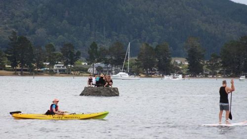 A photo of seven people sitting on an estuary sand island was posted to a local Facebook group. (Facebook/David Saunders)