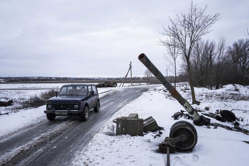A car drives past a destroyed tank at the former positions of Russian forces in Ridkodub village, Ukraine, Wednesday, Feb. 15, 2023 
