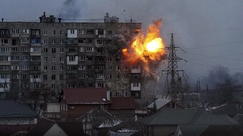 O explozie a făcut o gaură în lateralul unui bloc de apartamente după ce un tanc rus a tras o rachetă în Mariupol, Ucraina.