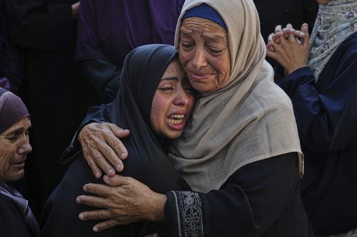 Relatives of Palestinians killed in Israeli strikes on the Gaza Strip mourn their deaths at Al-Shifa Hospital in Gaza City, Saturday, June 28, 2025. (AP Photo/Jehad Alshrafi)